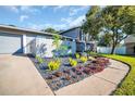 Modern front yard landscaping with black gravel and various plants at 7115 Edenwood Pl, Tampa, FL 33615