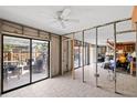 View of unfinished basement with sliding doors to the outside, ceiling fans, and lots of potential at 712 1St Ct, Palm Harbor, FL 34684