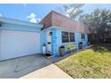 Inviting blue home with a white garage door, a white front door, and a cozy yellow bench at 8445 Jeffrey N # 8445, Pinellas Park, FL 33781