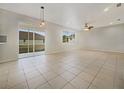 Spacious living area with tile flooring, neutral walls, and natural light from windows and sliding doors at 9003 Willowbrook Cir, Bradenton, FL 34212