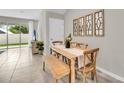 Dining room featuring a wooden table with chairs and bench, decorative wall mirrors, and sliding glass doors at 11850 Davis Dr, Largo, FL 33774