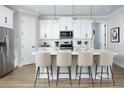 Bright kitchen with white cabinets, stainless steel appliances, large island, and pendant lighting at 12339 Hearts Ease St, Venice, FL 34293