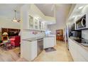Bright kitchen features white cabinetry, granite countertops, modern appliances and tiled floors at 13255 Don Loop, Spring Hill, FL 34609