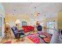 Spacious living room featuring hardwood floors, high ceilings, a ceiling fan, and large windows for natural light at 13255 Don Loop, Spring Hill, FL 34609