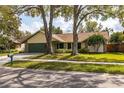 Charming single-story home featuring lush landscaping, a two-car garage, and a well-maintained front yard at 1740 Shady Leaf Dr, Valrico, FL 33596