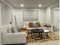 Bright living room features a white sofa, chair, contemporary rug, neutral tones, and natural light from the windows at 2613 E 23Rd Ave, Tampa, FL 33605