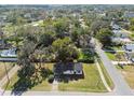 Aerial view of a cozy single story home nestled among mature trees in a charming neighborhood at 38638 2Nd Ave, Zephyrhills, FL 33542