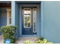 Elegant front door featuring glass panels and sidelights, complemented by lush greenery at 4549 Chinkapin Dr, Sarasota, FL 34232