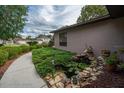 Peaceful side yard view with manicured greenery, stone accents, a charming water feature, and a paved walkway at 5443 Ott Ct, Spring Hill, FL 34608