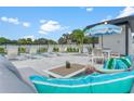 An inviting pool area featuring lounge seating, tables, and decorative umbrellas for a relaxing outdoor experience at 6213 64Th N Way, Pinellas Park, FL 33781