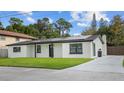 Inviting single-story home featuring a green lawn, dark trim, and solar panels at 6291 63Rd N St, Pinellas Park, FL 33781