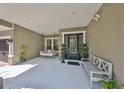 Inviting front porch with sitting bench and hanging swing at 6640 Park Strand Dr, Apollo Beach, FL 33572