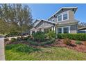 Landscaped front yard with grass, plants, mulch and a large tree at 6640 Park Strand Dr, Apollo Beach, FL 33572
