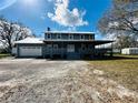 Charming two-story home with a large front porch and a well-maintained gravel driveway at 7705 W Four Pines Rd, Plant City, FL 33565