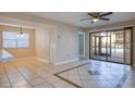 Bright living room with tiled floors, a sliding glass door, and a modern ceiling fan at 10195 Sailwinds N Blvd # 101, Largo, FL 33773