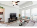 Cozy living room with large windows, neutral-toned sofa, ceiling fan, and stylish decor at 11717 74Th E Cir, Palmetto, FL 34221