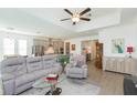 Open-concept living room featuring modern furniture, a ceiling fan, and plenty of natural light at 11717 74Th E Cir, Palmetto, FL 34221