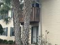 Close up of condominium exterior with sliding glass door, balcony, and palm trees at 121 Loblolly Ct # H, Oldsmar, FL 34677