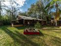 Secluded backyard with green grass, a mature trees, and a screened-in porch, creating a private outdoor space at 12950 Lincoln Rd, Riverview, FL 33578
