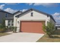 Well-maintained home with manicured lawn, neutral paint, and an attached two-car garage at 13515 Palmera Vista Dr, Riverview, FL 33579