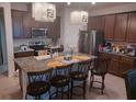 The gorgeous kitchen features an eat-in island, stainless steel appliances, and modern light fixtures at 13515 Palmera Vista Dr, Riverview, FL 33579