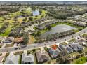 Scenic aerial view showcases neighborhood with ponds, golf course, and mature landscaping at 2449 E Del Webb Blvd, Sun City Center, FL 33573