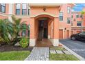 Exterior entrance to condo building featuring covered access, stairs, and manicured landscaping at 2747 Via Capri # 1122, Clearwater, FL 33764