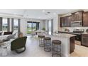 Open-concept kitchen with granite countertops, stainless steel appliances, and an adjacent dining and living area at 3832 Turning Tides Ter, Bradenton, FL 34208