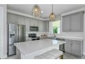 Modern kitchen features gray cabinets, stainless steel appliances, white countertops, and kitchen island seating at 4227 Big Sky Dr, Spring Hill, FL 34604