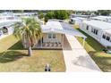 Aerial view of single-story home featuring carport, palm tree and neat landscaping at 5238 Vera St, Zephyrhills, FL 33542