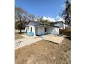View of the home's side and back exterior with a small yard and partial fence in a neighborhood at 5511 N 32Nd St, Tampa, FL 33610