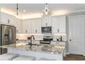 Bright kitchen features stainless steel appliances, white cabinetry, and a granite countertop island at 6206 Timberdale Ave, Wesley Chapel, FL 33545
