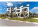 Beautiful townhomes showcasing modern design, black accents, a rooftop terrace, and a well-kept front yard at 6207 64Th N Way, Pinellas Park, FL 33781