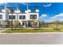 Charming townhome featuring a modern exterior with a black fence, a manicured lawn, and a rooftop deck at 6207 64Th N Way, Pinellas Park, FL 33781