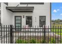 Inviting porch with stylish seating, a decorative fence, and a modern door under a gray awning at 6207 64Th N Way, Pinellas Park, FL 33781
