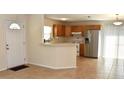Open-concept kitchen featuring stainless steel appliances and a breakfast bar area at 7411 S Elliott St, Tampa, FL 33616