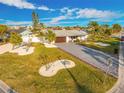 An aerial view of a single-story house with manicured landscaping, a stone paver driveway and a beautiful lawn at 1029 Bal Harbour Dr, Apollo Beach, FL 33572