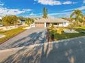 An exterior shot of a single-story house featuring a stone paver driveway and well-manicured landscaping at 1029 Bal Harbour Dr, Apollo Beach, FL 33572