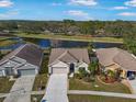 Aerial view of a single-story home situated on the water, nestled between two neighboring homes in a quiet community at 10448 Hallmark Blvd, Riverview, FL 33578