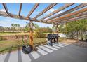 Outdoor patio featuring a wooden pergola, gas grill, and a view of the fenced backyard, perfect for entertaining at 10448 Hallmark Blvd, Riverview, FL 33578