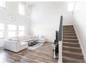 Bright living room boasting high ceilings, hardwood floors, contemporary furnishings, and a staircase leading to the second floor at 11539 Tangle Branch Ln, Gibsonton, FL 33534
