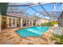 Sparkling screened pool with lounge area, outdoor kitchen, and seamless indoor/outdoor living at 1734 Kinsmere Dr, Trinity, FL 34655