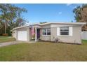Quaint single-story home with well-kept lawn and a patriotic American flag flying near the entrance at 1773 Ezelle Ave, Largo, FL 33770