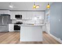 Modern kitchen featuring white cabinetry, stainless steel appliances, light wood floors and marble countertops at 2 N Fernwood Ave # 33, Clearwater, FL 33765