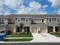 View of multiple townhouses featuring garages, neutral paint schemes, and well-maintained landscaping at 2411 Paravane Way, Wesley Chapel, FL 33543