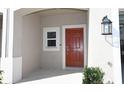 Inviting front door with a covered porch, modern lighting, and views of the private garage at 2411 Paravane Way, Wesley Chapel, FL 33543