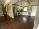 Open kitchen with stainless appliances, white cabinets, and dark floors at 3223 Coats Rd, Zephyrhills, FL 33541