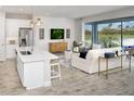 Open-concept living space with island seating, great backyard views, and comfortable, bright modern furniture at 5020 124Th E Ave, Parrish, FL 34219