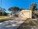 A property featuring a detached garage, a long driveway, and a well-maintained lawn at 5495 80Th N Ave, Pinellas Park, FL 33781