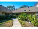 Charming exterior view showcasing the home's landscaping and well-lit walkway at 707 Old Mill Pond Rd, Palm Harbor, FL 34683